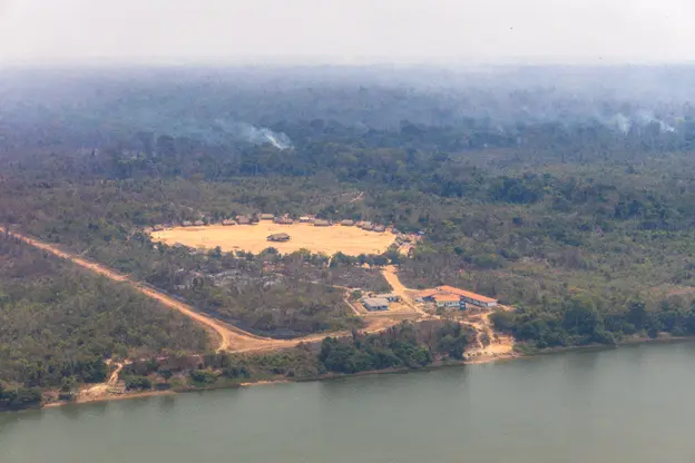 Aldeia Metuktire, à beira do Rio Xingu, onde vive o cacique Raoni, cercada por ar esfumaçado e paredões de fumaça, que mostram fogo ativo. Crédito: Marizilda Cruppe/Greenpeace Brasil